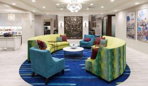 a lobby with couches and chairs on a blue rug at Homewood Suites by Hilton Cape Canaveral-Cocoa Beach in Cape Canaveral