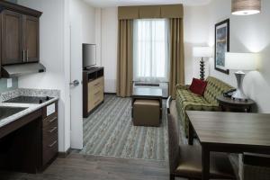 um quarto de hotel com um sofá e uma sala de estar em Homewood Suites by Hilton Cape Canaveral-Cocoa Beach em Cape Canaveral