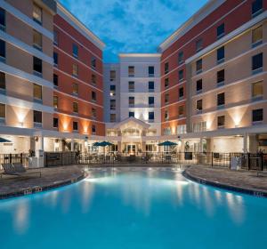 uma piscina no pátio de um hotel à noite em Hampton Inn & Suites Cape Canaveral Cruise Port, Fl em Cape Canaveral