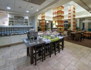 un restaurante con una línea de buffet con mesas y sillas en Hilton Garden Inn Tallahassee Central en Tallahassee