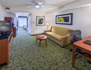 a living room with a couch and a tv at Hilton Garden Inn Tallahassee Central in Tallahassee