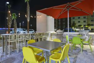 a table and chairs and an umbrella on a patio at Home2 Suites By Hilton Panama City Beach, Fl in Panama City Beach