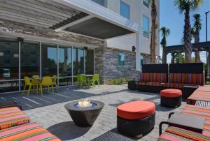 a patio with a fire pit and tables and chairs at Home2 Suites By Hilton Panama City Beach, Fl in Panama City Beach