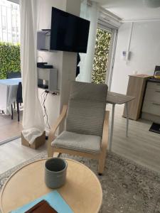salon z krzesłem i stołem w obiekcie Apartment cosy with terrace 200m from the sandy beaches wifi w mieście Juan-les-Pins