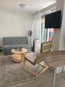 a living room with a couch and a table at Apartment cosy with terrace 200m from the sandy beaches wifi in Juan-les-Pins