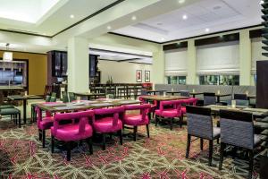 a restaurant with pink chairs and tables in a room at Hilton Garden Inn Victoria in Victoria