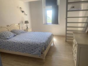 a bedroom with a bed with a blue comforter and a ladder at château le perchoir in Montélimar