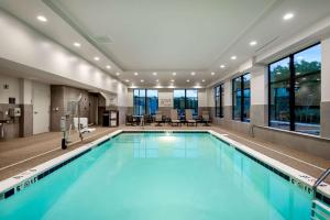 a large swimming pool with blue water in a building at Hampton Inn Baltimore Bayview Campus in Baltimore
