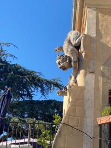 a statue of a gargoyle on the side of a building at château le perchoir in Montélimar +5 photos