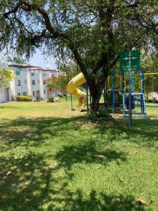 une aire de jeux dans un parc avec un toboggan jaune dans l'établissement Casa Gayatri Teques, à Tequesquitengo