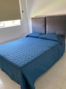- un lit dans une chambre avec une couette bleue dans l'établissement Casa Gayatri Teques, à Tequesquitengo