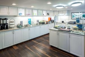 a large kitchen with white cabinets and wooden floors at Homewood Suites by Hilton Chattanooga - Hamilton Place in Chattanooga