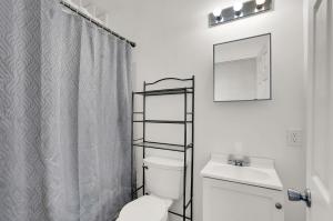 a bathroom with a toilet and a shower curtain at The Village Downtown West in Indianapolis