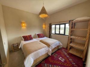 um quarto com 2 camas e uma janela em La Villa Tamazirt, Sidi Kaouki em Essaouira