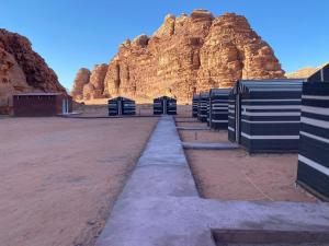 una fila de retretes frente a una montaña en Bedouin Memories Camp, en Wadi Rum