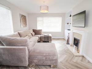 a living room with a couch and a fireplace at 4 Bodnant Road in Colwyn Bay