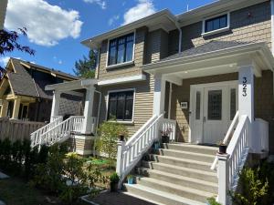 une maison avec une porte d'entrée blanche et des escaliers dans l'établissement Windsor Guest House, à Vancouver