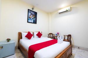 um quarto com uma cama grande e almofadas vermelhas em Mai Phương - RUBY SAIGON HOTEL em Cidade de Ho Chi Minh