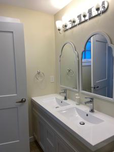 une salle de bain avec un lavabo blanc et un miroir dans l'établissement Windsor Guest House, à Vancouver 37 autres photos