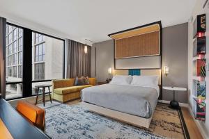 a bedroom with a king sized bed and a living room at Canopy By Hilton Memphis Downtown in Memphis
