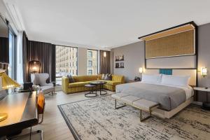 孟菲斯Canopy By Hilton Memphis Downtown的一间带床和客厅的酒店房间