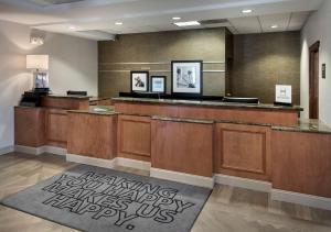 a waiting room with a reception desk with a sign on the floor at Hampton Inn Boston Logan Airport in Boston