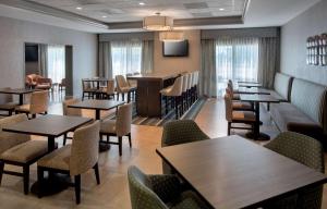 a restaurant with tables and chairs and a bar at Hampton Inn Boston Logan Airport in Boston