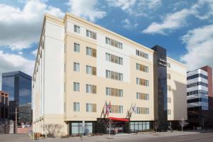 Hampton Inn & Suites Denver-Downtown في دنفر: مبنى أمامه أعلام أمريكية