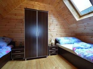 a room with two beds in a wooden cabin at Sosnowe Domki in Sarbinowo