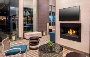 a living room with a fireplace and a tv at Hilton Garden Inn NYC Financial Center/Manhattan Downtown in New York