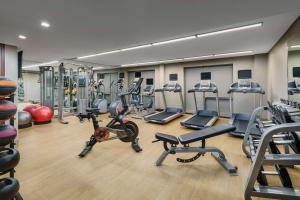 - une salle de sport avec plusieurs tapis de course et vélos d'exercice dans l'établissement Hilton Garden Inn New York Times Square North, à New York