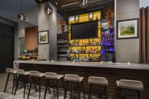 a bar with stools and a flat screen tv at Hilton Garden Inn New York Times Square North in New York
