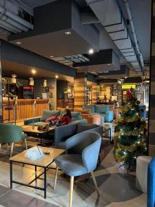 a lobby with a christmas tree and people sitting on couches at Arboro Borovets Gardens E68 in Borovets