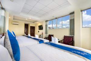 胡志明市的住宿－Mai Phương - RUBY SAIGON HOTEL，酒店客房 - 带4张带蓝色枕头的床