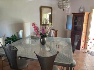 a dining room table with a vase of flowers on it at Entre vigne et Camargue in Générac