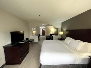 a bedroom with a large bed and a flat screen tv at Comfort Suites in Milledgeville