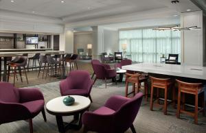 a lobby with purple chairs and tables and a bar at Hilton Garden Inn Atlanta-Buckhead in Atlanta