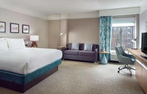 a hotel room with a bed and a couch at Hilton Garden Inn Atlanta-Buckhead in Atlanta