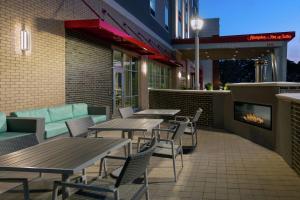 a patio with tables and chairs and a fireplace at Hampton Inn & Suites Atlanta Buckhead Place in Atlanta