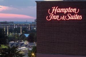 Hampton Inn & Suites Atlanta-Downtown في أتلانتا: علامة لنزل هامبتون والأجنحة على جانب المبنى