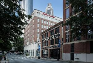 Hampton Inn & Suites Atlanta-Downtown في أتلانتا: مبنى عليه لافته لفندق على شارع