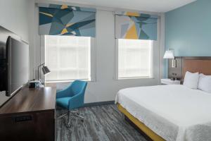 Hampton Inn & Suites Atlanta-Downtown في أتلانتا: غرفة في الفندق بها سرير ومكتب وتلفزيون