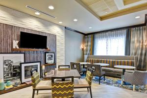 a waiting room with tables and chairs and a tv at Hampton Inn Atlanta Kennesaw in Kennesaw