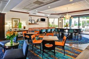 a dining room with tables and chairs and windows at Hampton Inn Boca Raton in Boca Raton