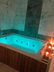 Galata istanbul Hotel في إسطنبول: حوض استحمام مع ضوء أزرق في الحمام