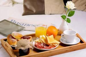 a tray with breakfast foods and orange juice on a bed at Imperial Lodges in Islamabad