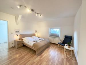 een slaapkamer met een bed en een stoel erin bij Möbliert-nahe Bochumer Ruhrstadion-WLAN-Netflix-Loggia in Bochum