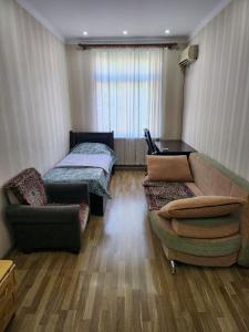 a living room with a couch and a bed at Апартаменты in Tashkent