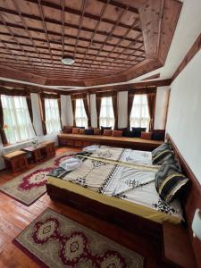 a bedroom with a large bed in a room with windows at Къща за гости Никула Чорбаджи in Zheravna