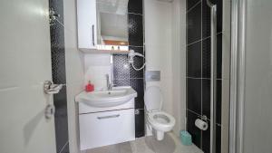 a small bathroom with a toilet and a sink at Duman Safir Rezidans in Kayseri +27 photos